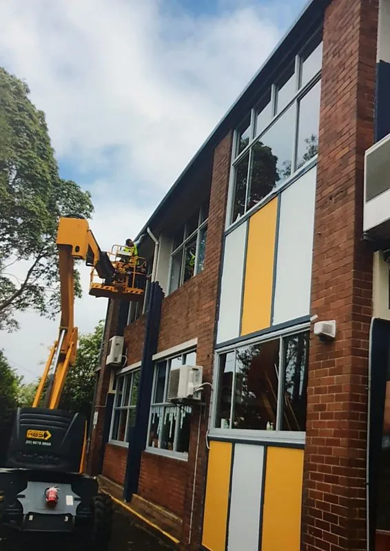 Exterior painting of commercial building from boom lift